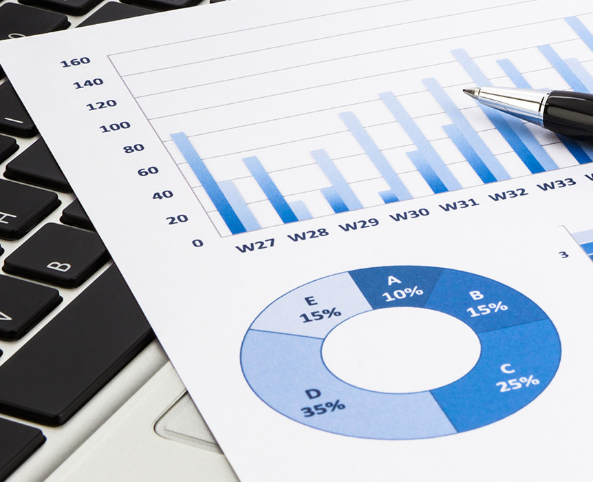 Financial charts, pen, and keyboard