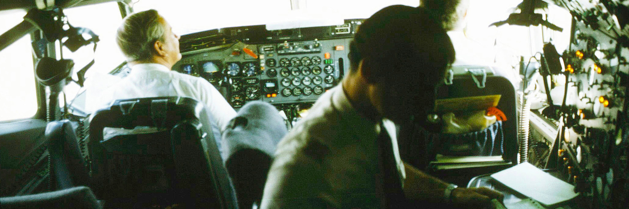 Jet flying toward globe of the Earth with stick figures standing around the globe in a circle holding hands