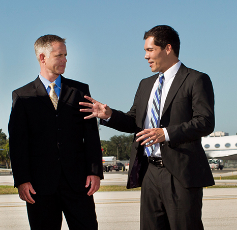 Two businessmen having a conversation on a runway