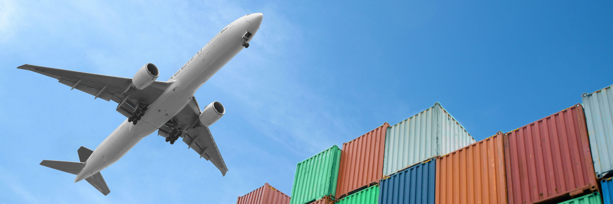 Plane flying over cargo containers