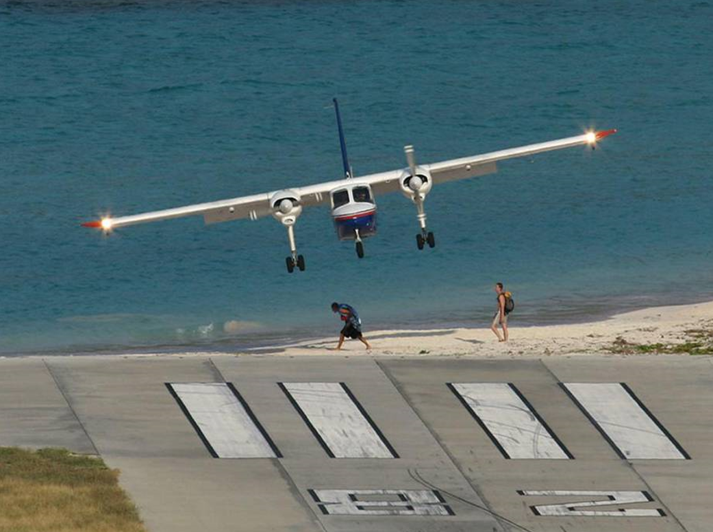 Small plane landing over beach