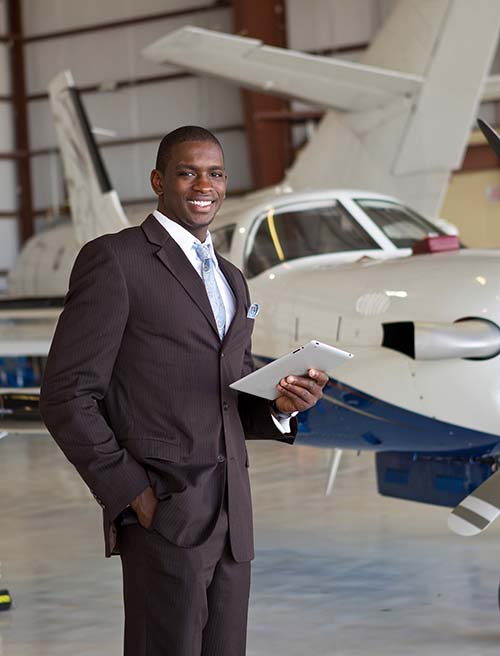 Confident businessman in airplane hangar