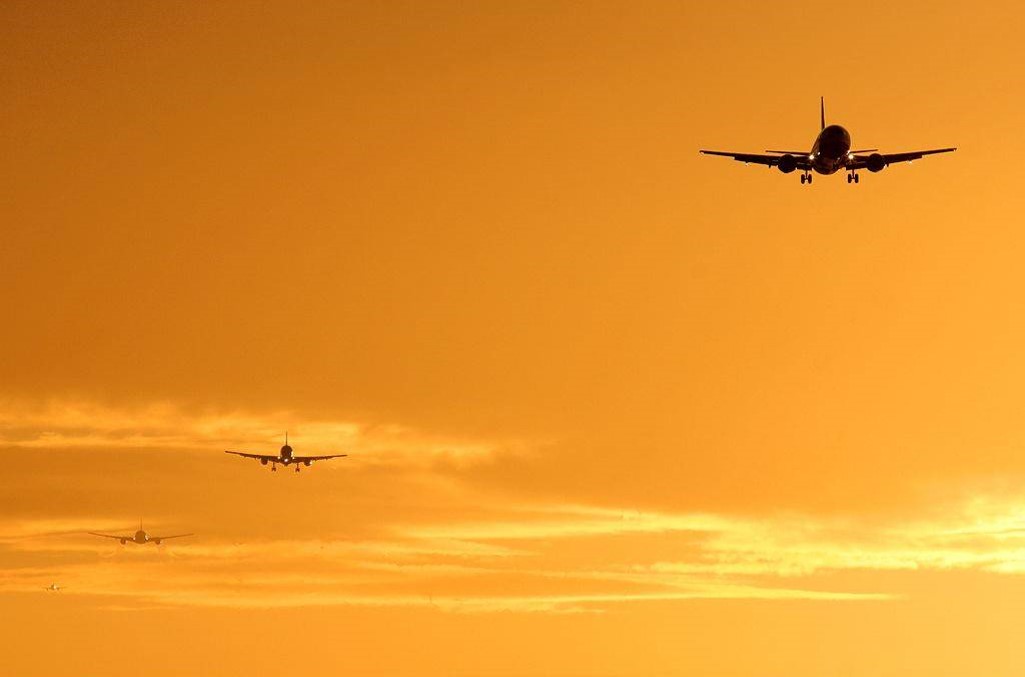 Incoming plane silhouettes at sunset