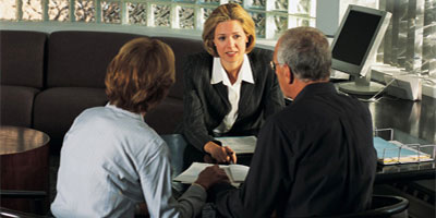 Couple holding hands at businesswoman's desk