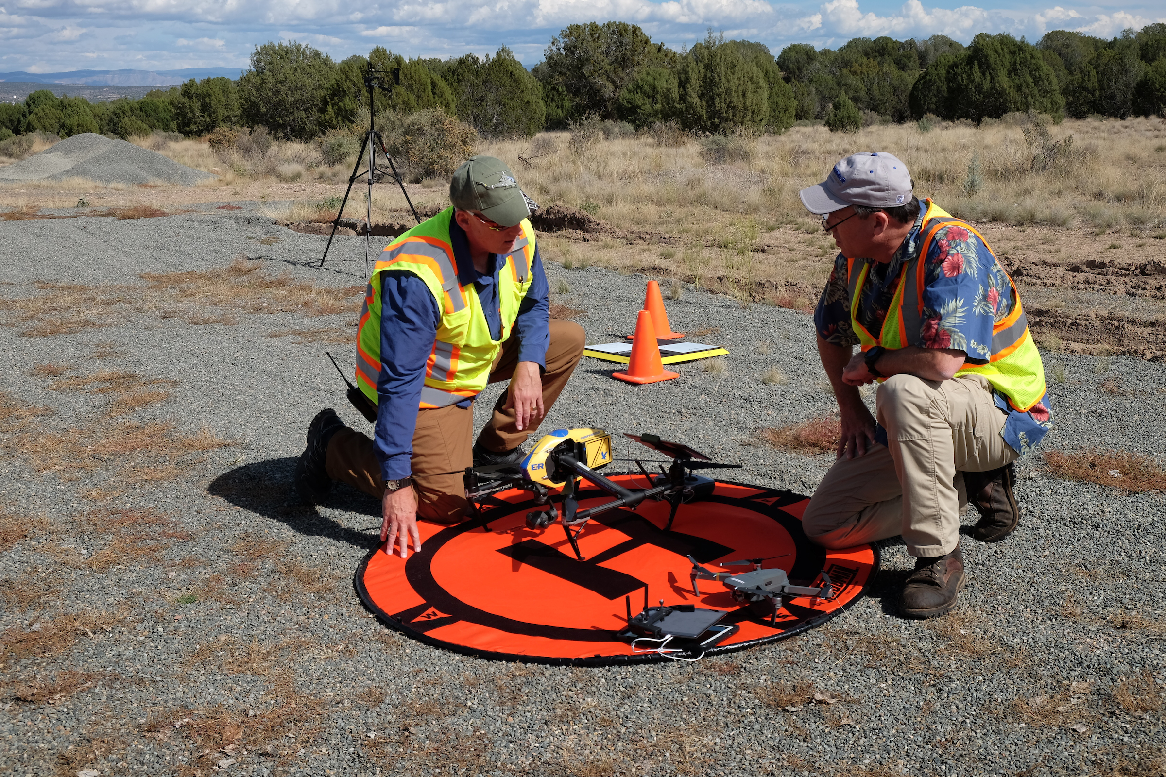 Two people setting up sUAS landing pad