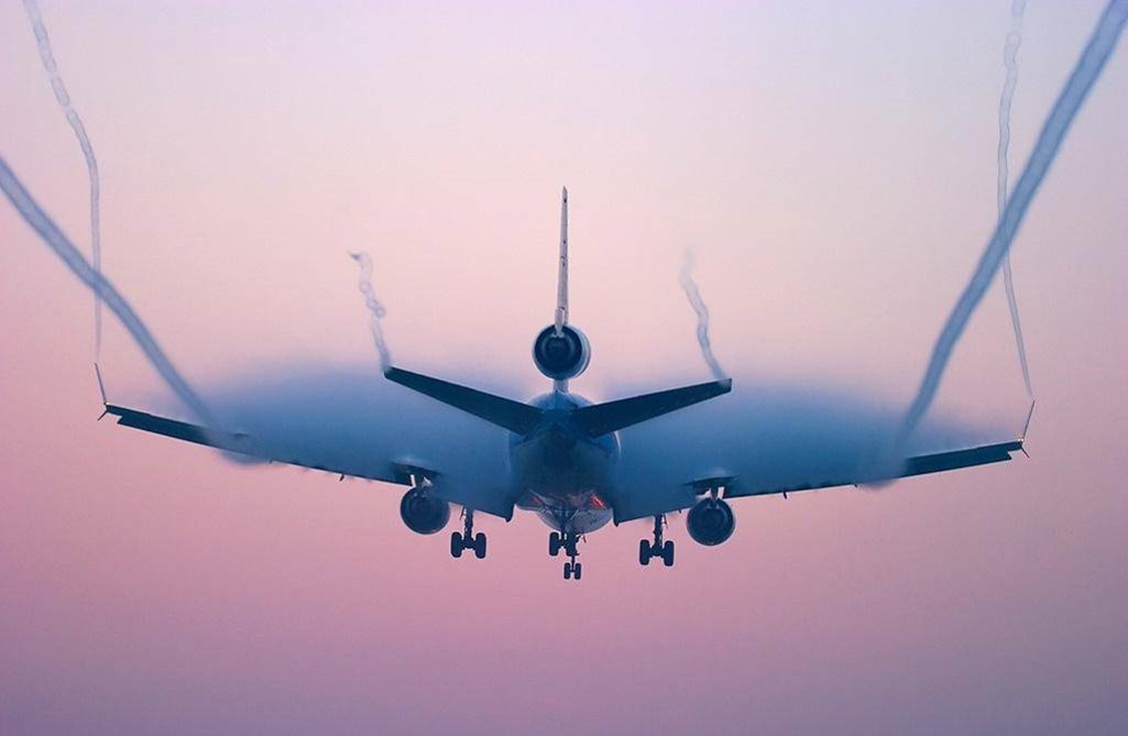 Contrails forming behind plane in flight