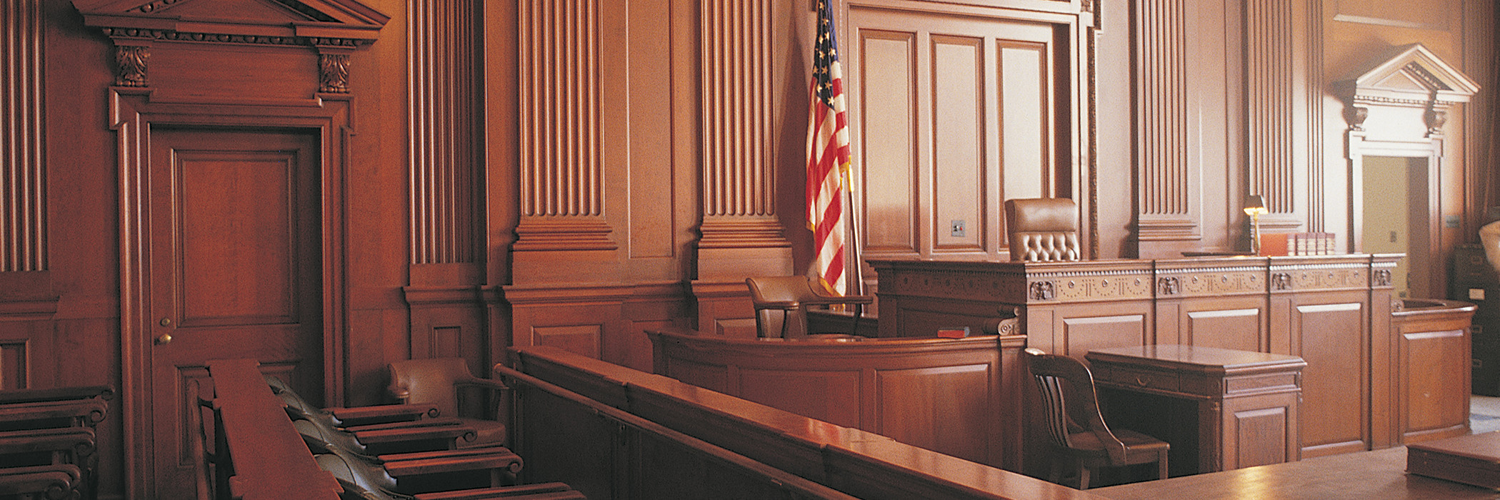 Empty wood-paneled courtroom with American flag