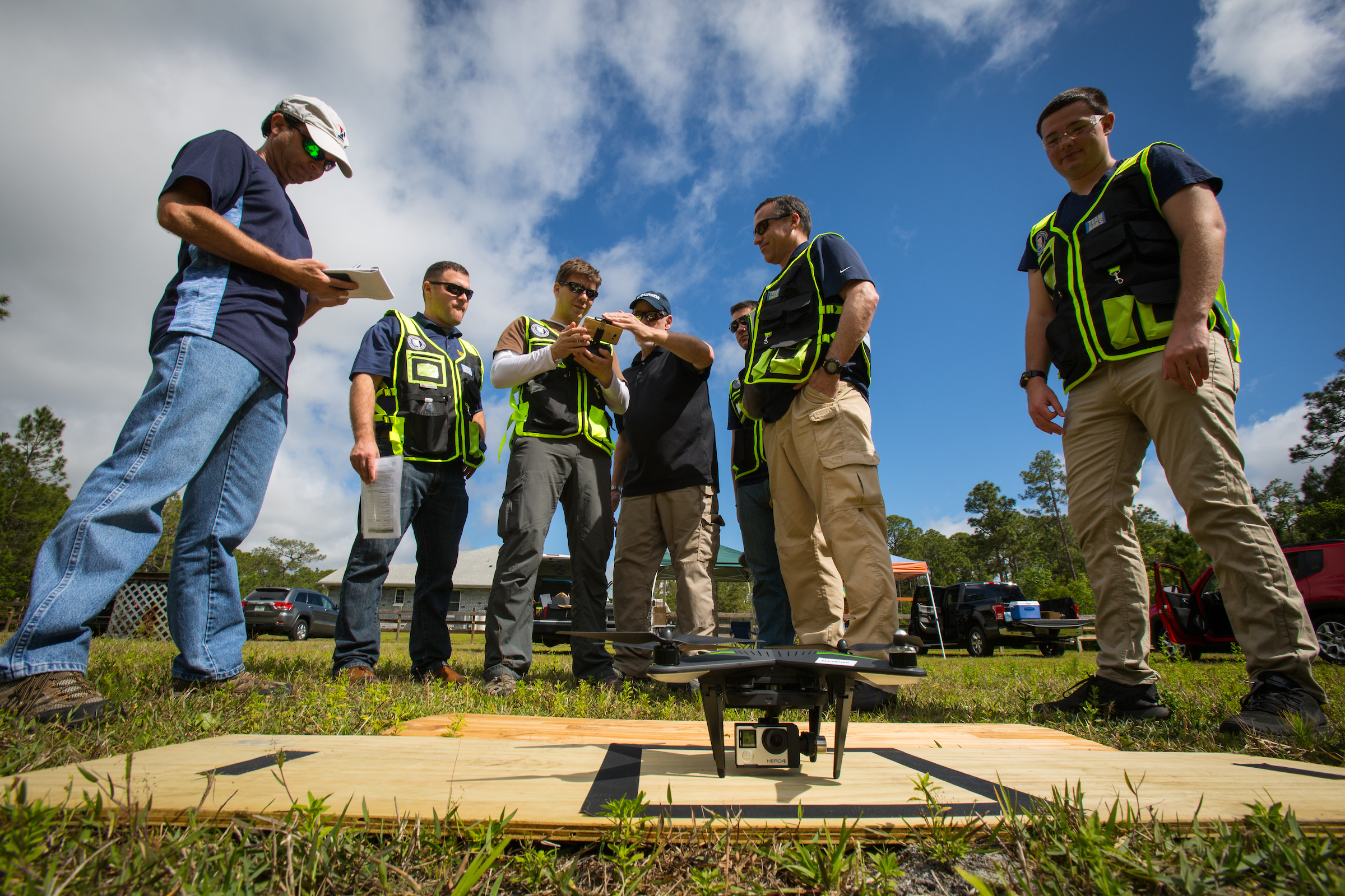 Operating team surrounding sUAS on launch pad