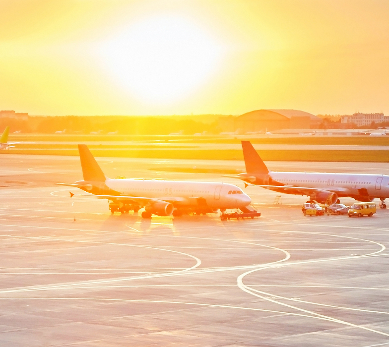Airplanes on runway at sunset
