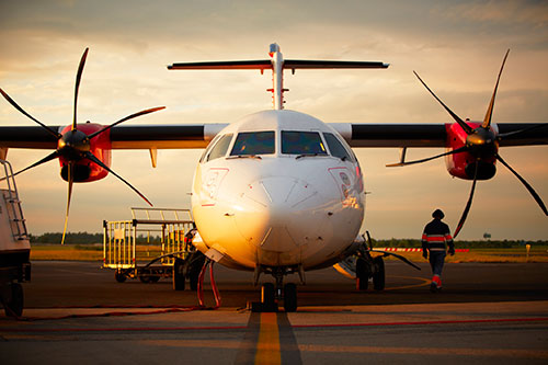 Propeller plane and landing crewperson on runway