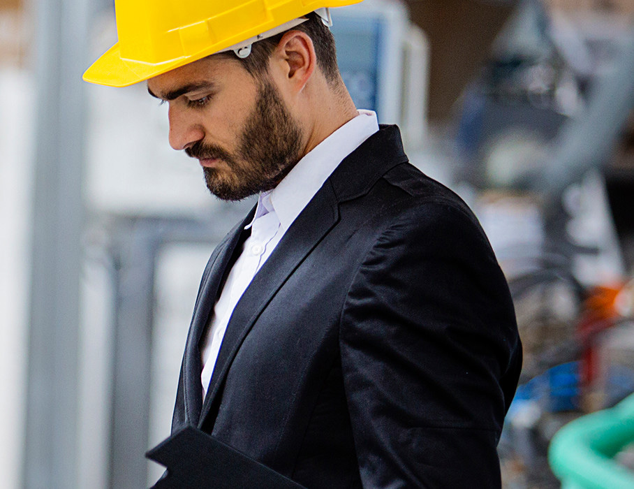 Businessman in hard hat on assembly line