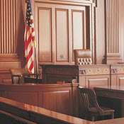 Empty wood-paneled courtroom with American flag