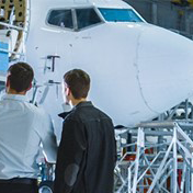 Two aviation professionals examining an aircraft under repair