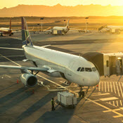 Airplanes and jet bridge at sunset