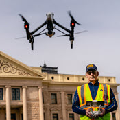 Operator flying sUAS in front of historic-looking building