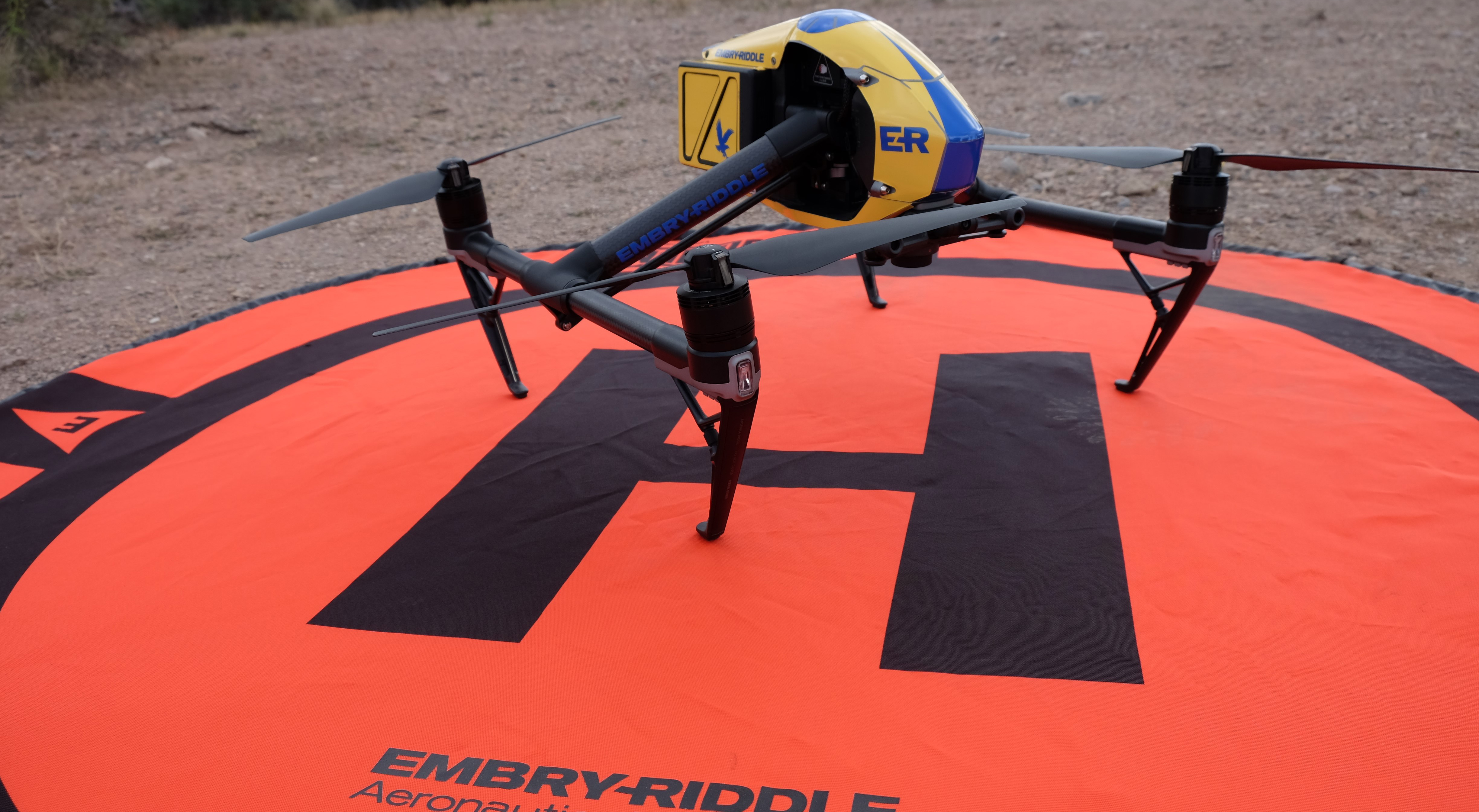 a quadrotor drone sits on a landing pad