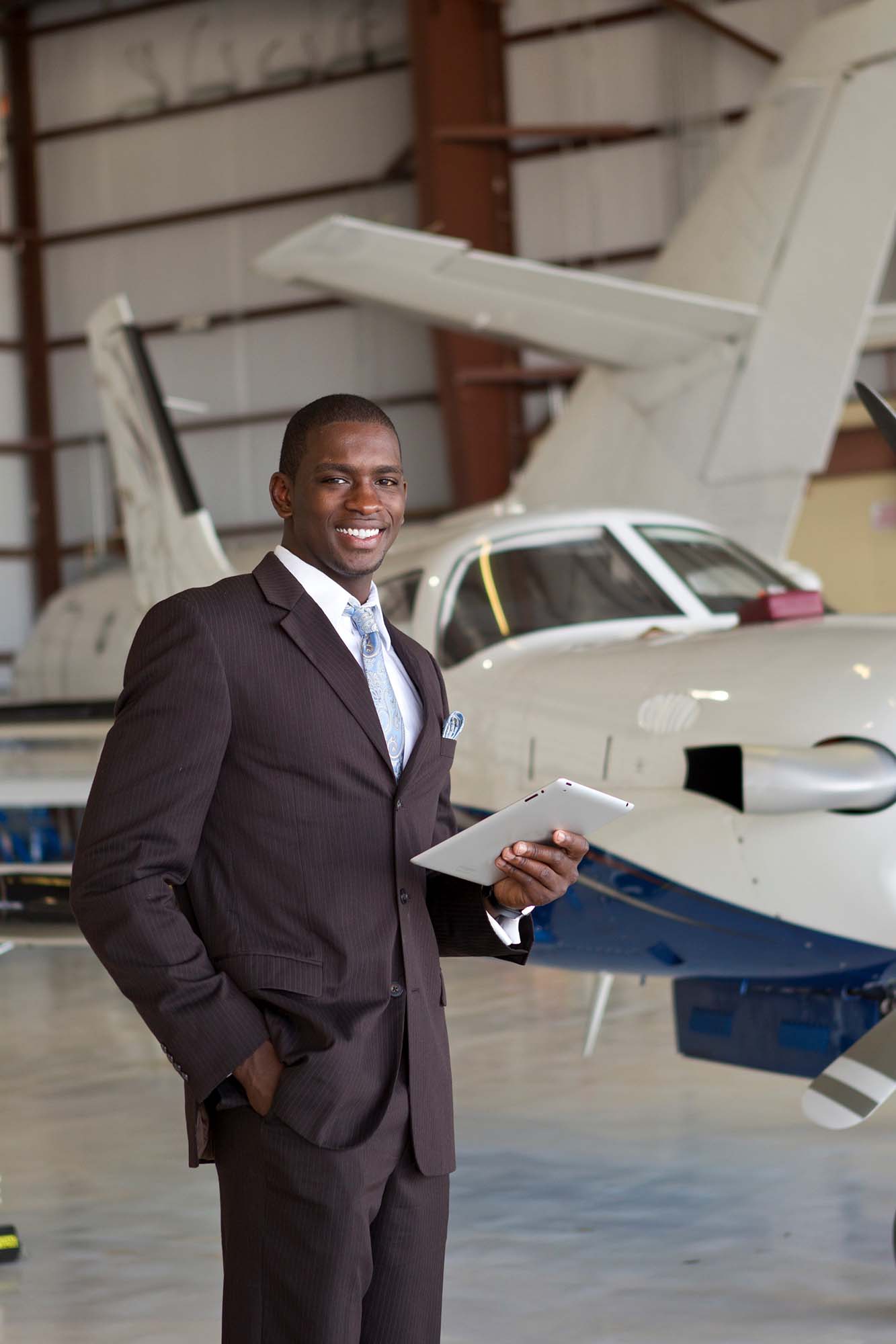 Confident businessman in airplane hangar