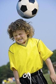 photo of boy getting hit by soccer ball
