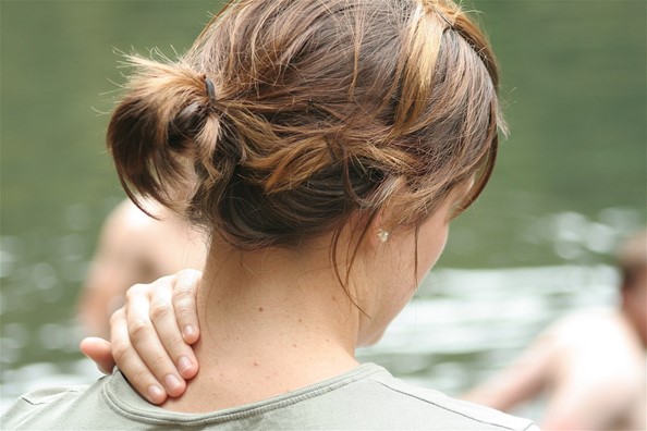 women rubbing her sore neck shoulder area